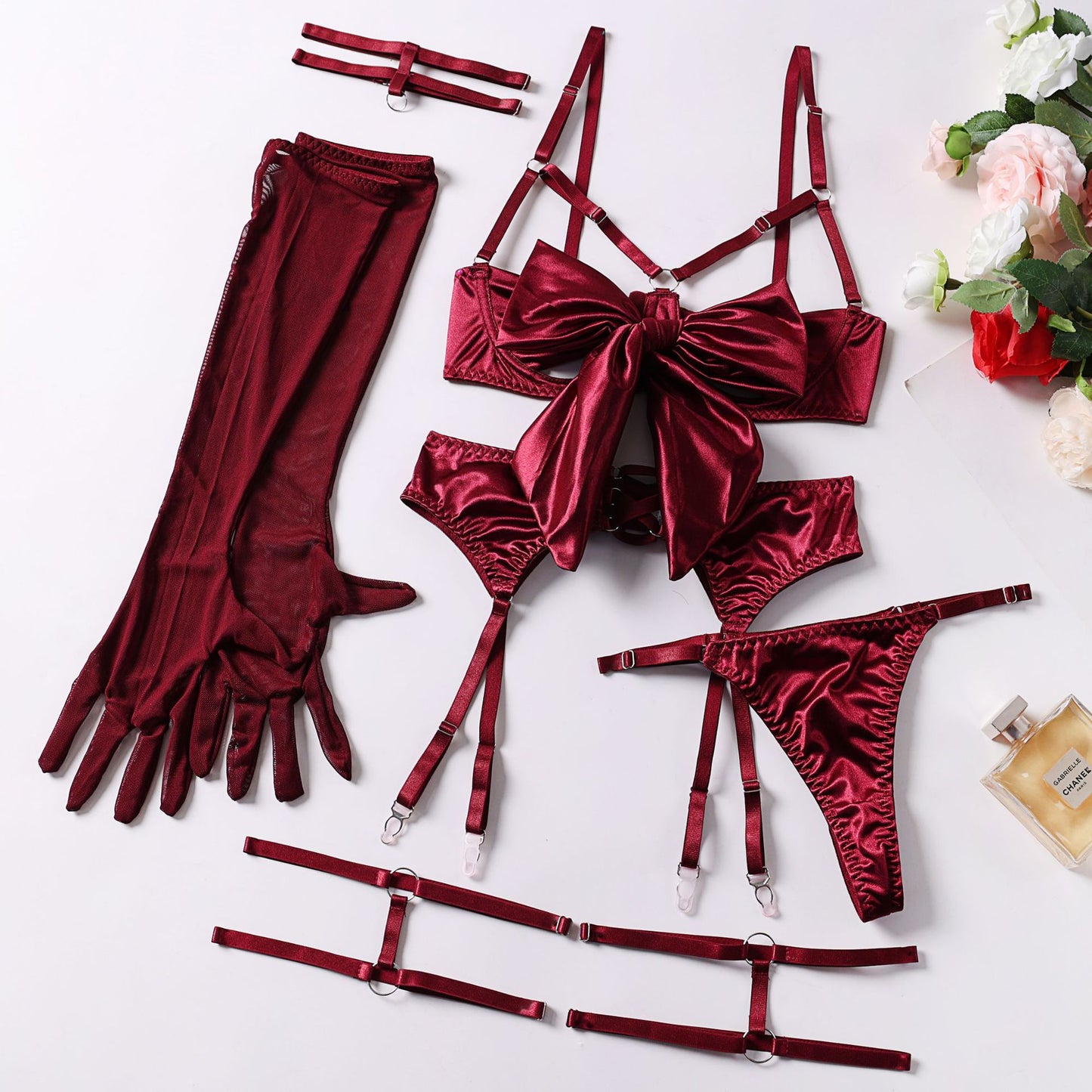 Sensual lingerie set with bow and garter belt by Dnika, featuring lace details and adjustable straps on a model.