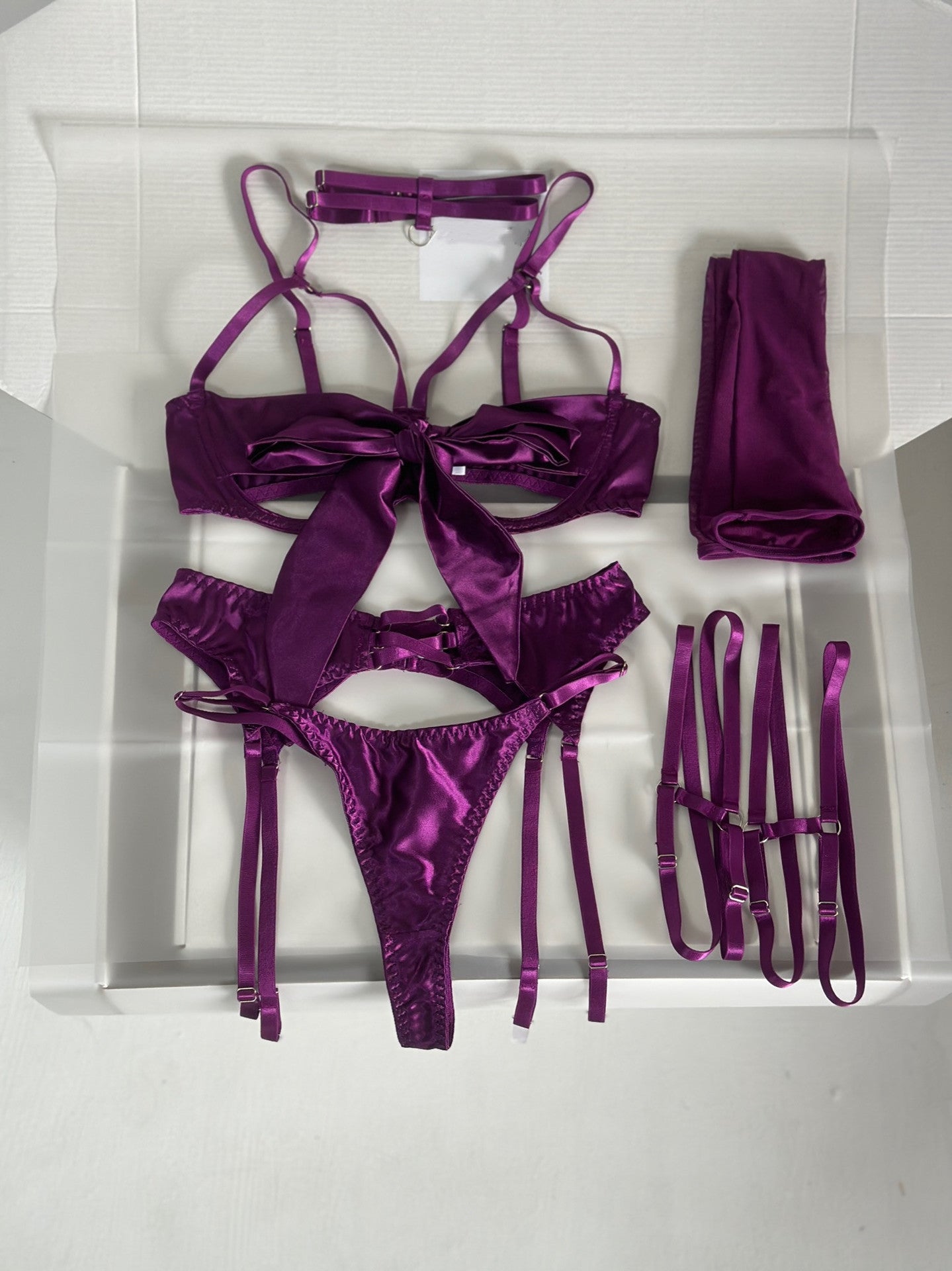 Sensual Dnika lingerie set with bow and garter belt, featuring delicate lace and feminine design, showcased on a model.